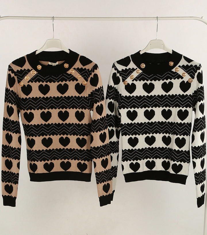 Two sweaters with heart and zigzag pattern on hangers