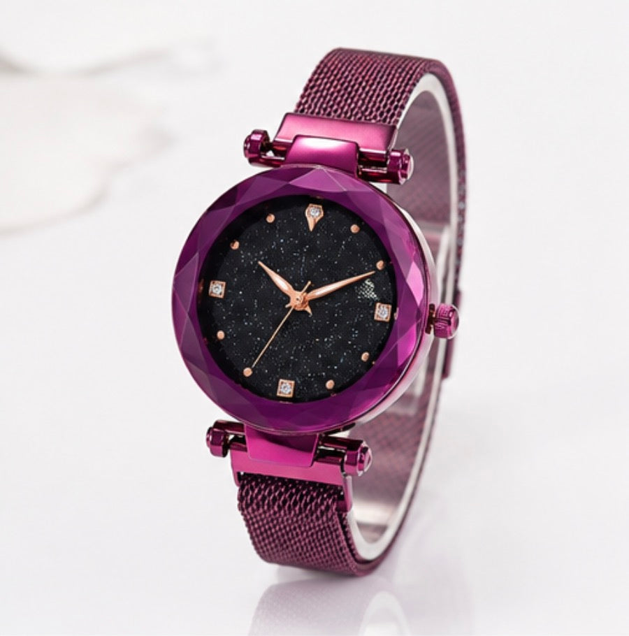 A women's analog watch with a faceted purple bezel, a black starry dial, rose gold-tone hands and markers, and a matching purple mesh strap, shown on a clean white background.