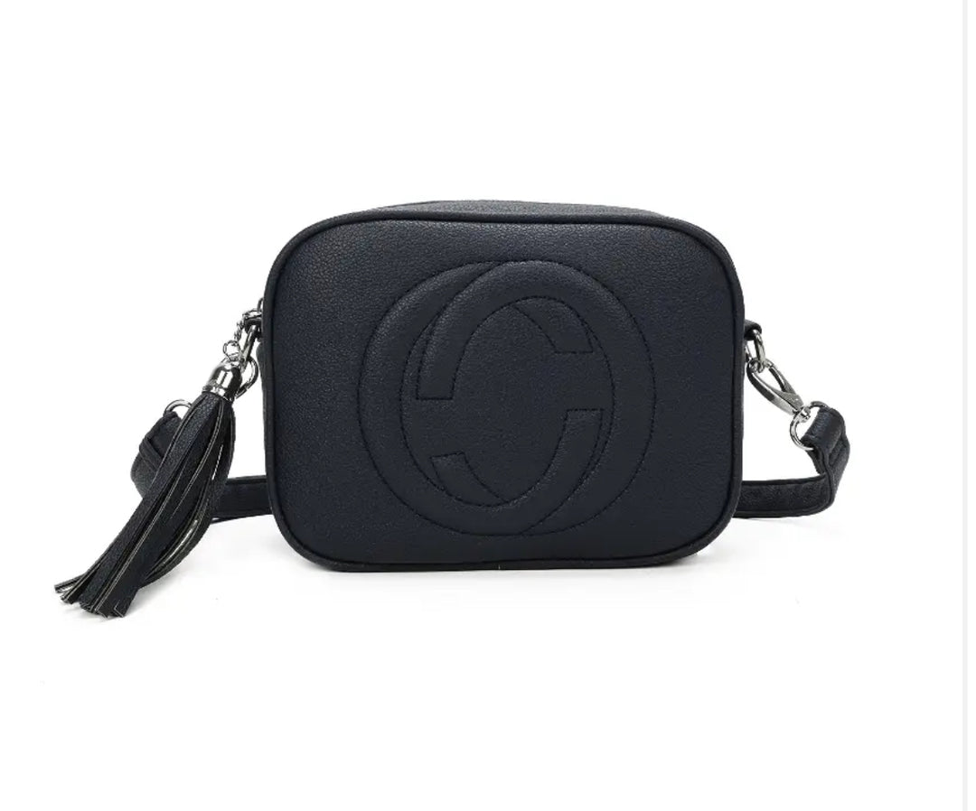 A navy crossbody camera bag with embossed circle logo design, detachable strap and tassel zip detail