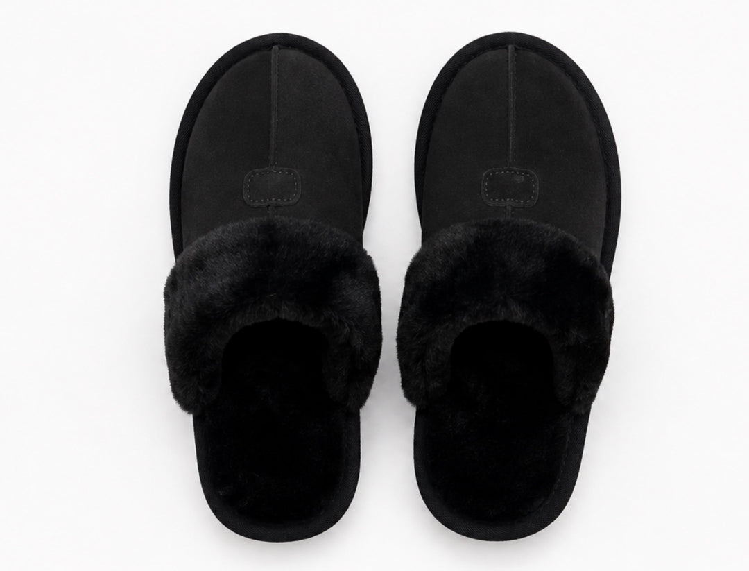 A pair of black slip-on slippers with plush faux-fur trim, shown from a top-down view on a plain white background.