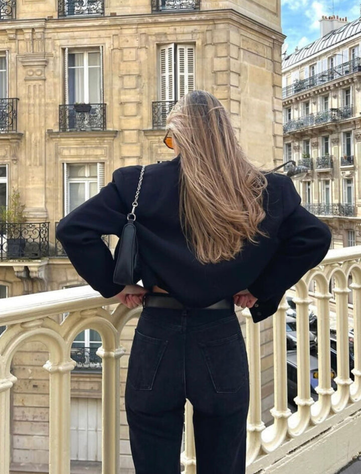 Black cropped bomber jacket styled with jeans and handbag, chic outfit