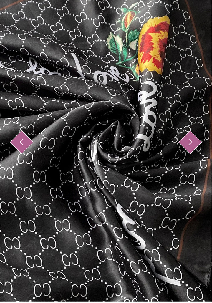 A black scarf with a geometric pattern and a multicoloured floral emblem.