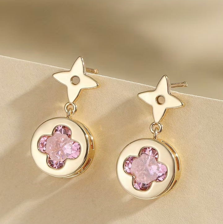     Gold clover drop earrings with pink crystal centre