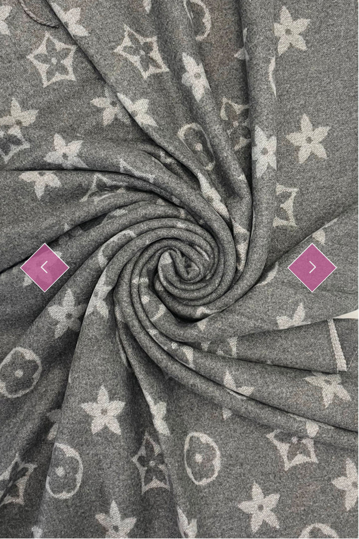 A grey scarf with sparkly metallic thread floral patterns, draped elegantly with a focus on the sparkly details.