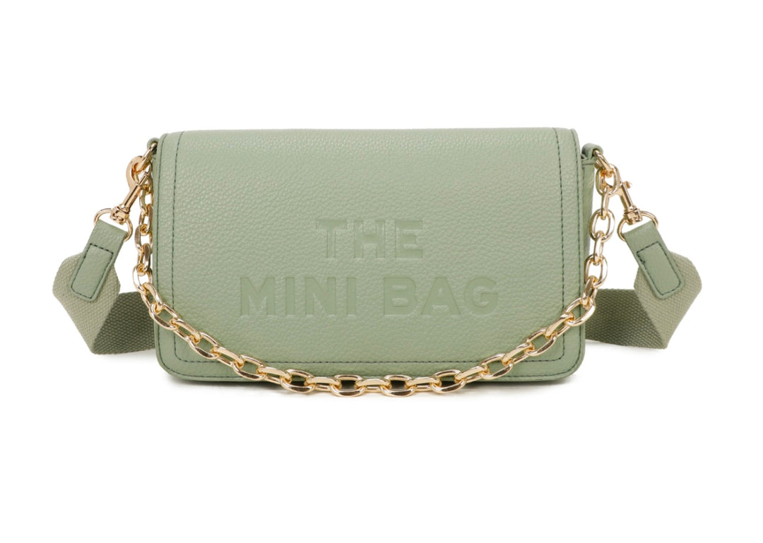 A green mini tote bag with a chain detail and the text &