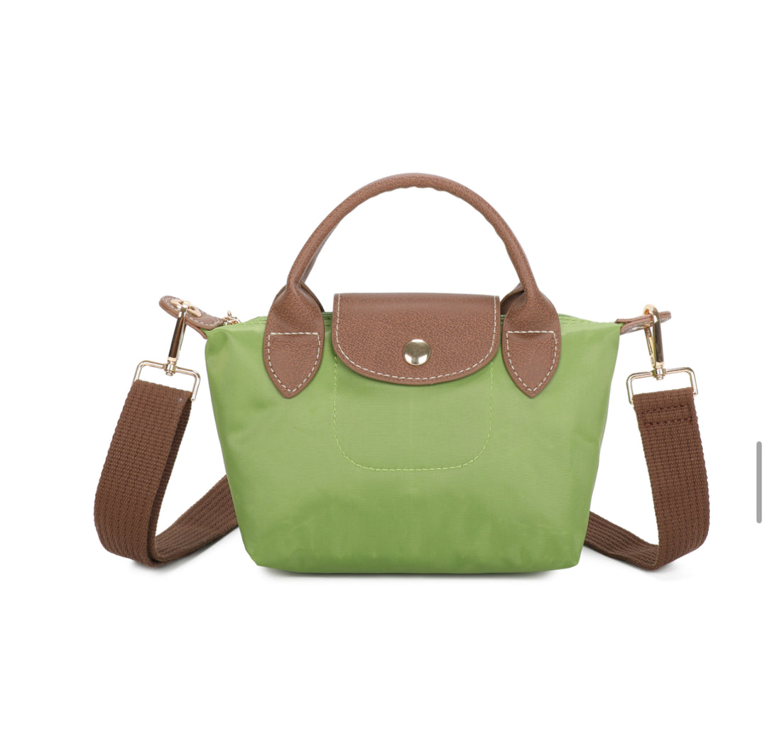 Green handbag with brown handles and strap on a white background