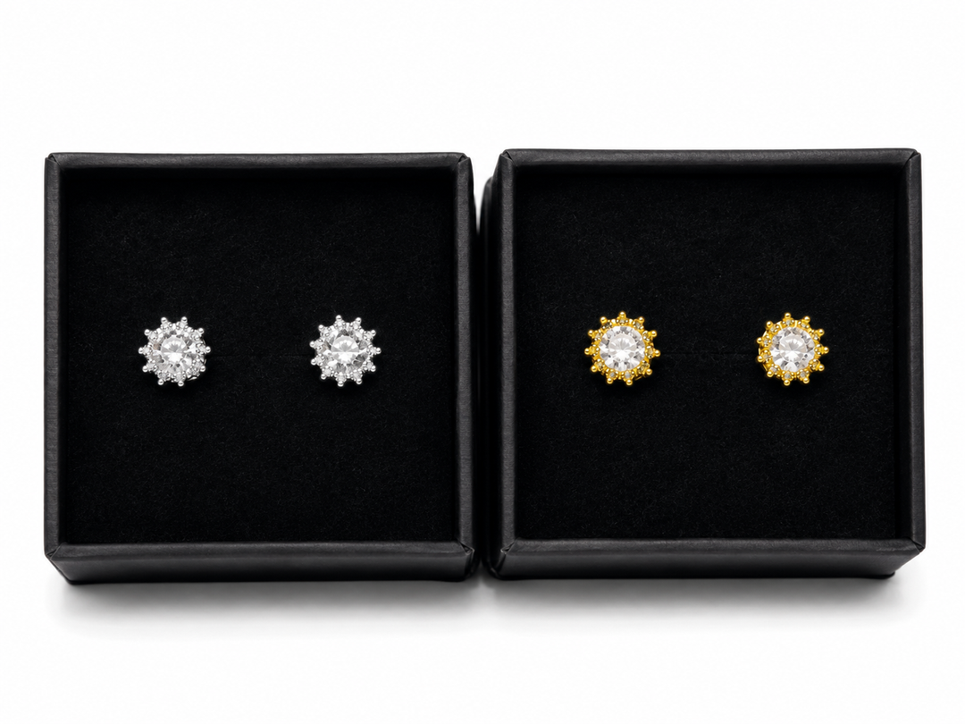 Silver and gold crystal crown stud earrings with sparkling round-cut stones displayed in black jewellery gift boxes.