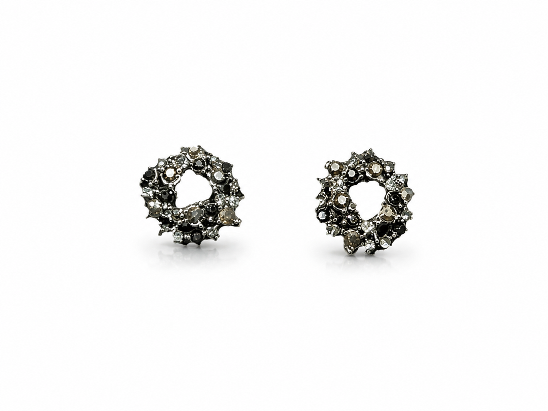 Black crystal wreath stud earrings with an open circular design and sparkling black, charcoal and clear crystals on a white background.