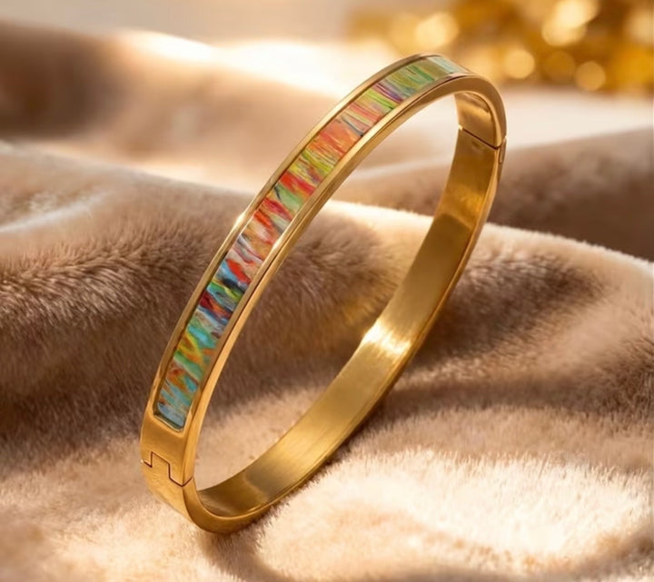 Assorted gold stainless steel statement bangles with crystal, colourful and Roman numeral designs.