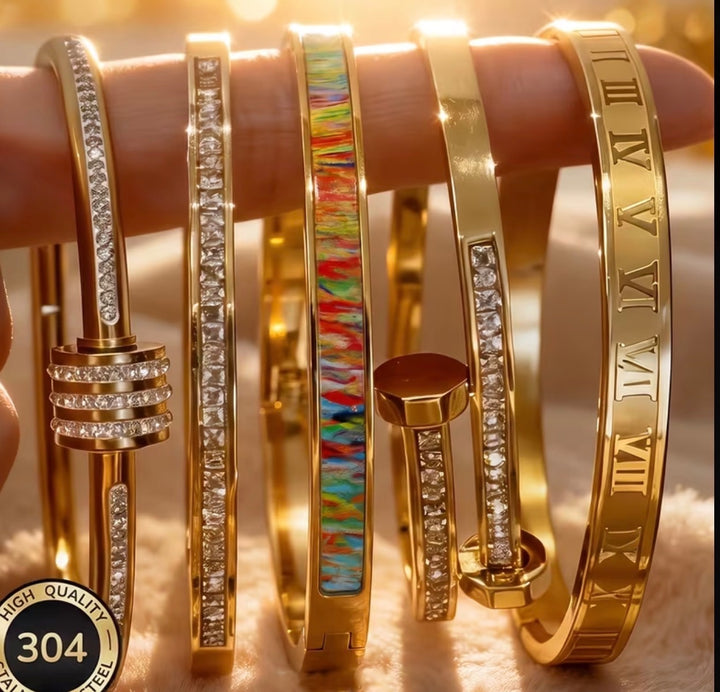 Assorted gold stainless steel statement bangles with crystal, colourful and Roman numeral designs.