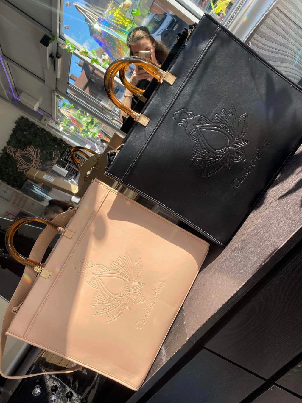 black and nude faux leather tote bag with the cbs logo on the front