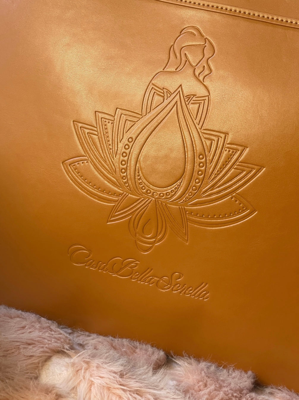 close up of tan faux leather tote bag with the cbs logo on the front