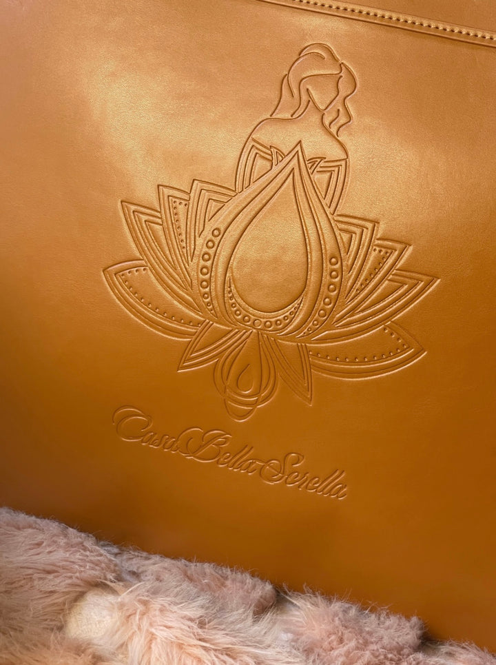 close up of tan faux leather tote bag with the cbs logo on the front