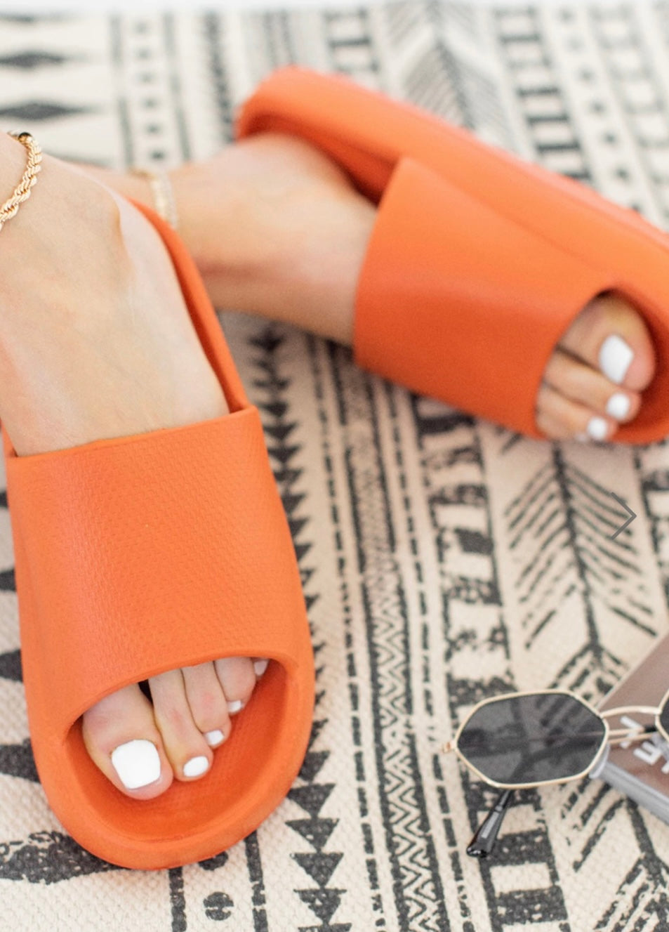 Orange slip on slider sandals with wide strap and cushioned sole