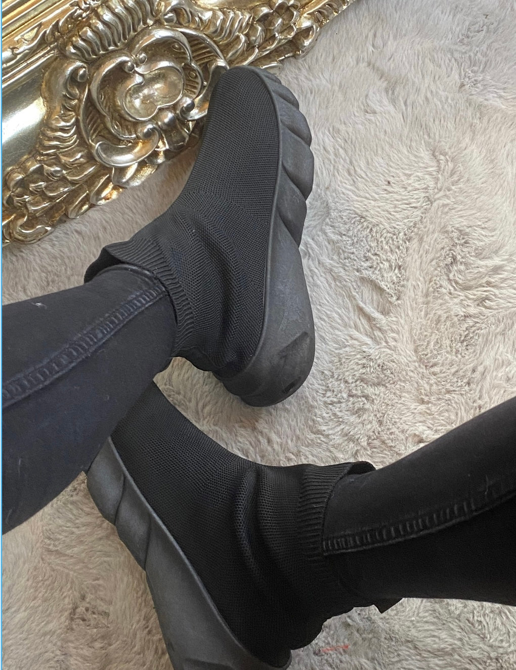 A pair of black sock-style slip on trainers