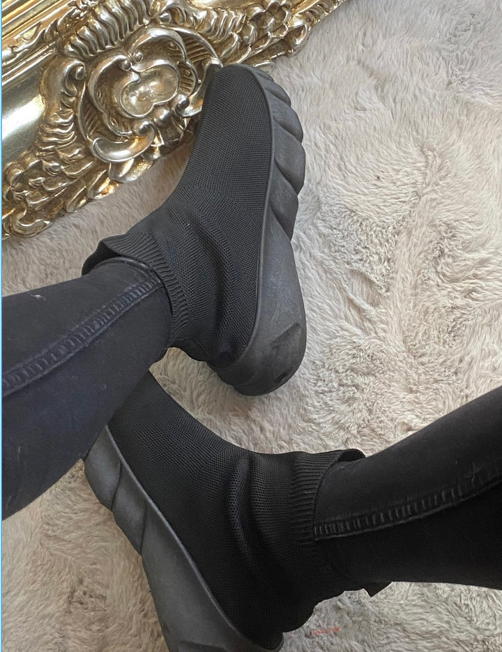 A pair of black sock-style slip on trainers