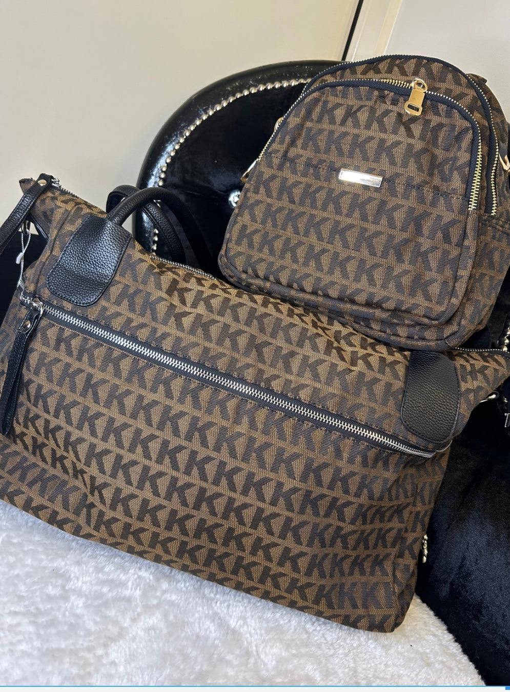 Matching brown monogram travel set with KK print – women’s backpack and large weekend duffle bag with black handles and gold zip details